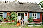 Family sitting on steps in Friseboda, Sweden