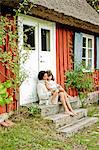 Mother and daughter sitting on steps in Friseboda, Sweden