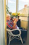 Senior man reading book in loggia