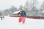 Girl holding a sled on snow
