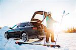 Man by a car with skiing equipment in Osterdalen, Norway