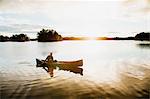 Man paddling canoe on lake