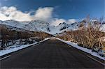 A snowy rural road with a mountain view in Norway