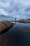 Woman standing by a rock pool in Vasterbotten, Sweden