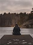 Rear view of man on wharf at Lake Flaten in Skarpnack, Sweden