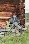 Mature man sitting on cabin step in Fatmomakke, Sweden