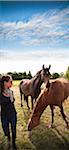 Woman standing next to horses