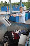 Woman throwing old toaster into container