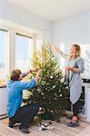 Couple decorating christmas tree together