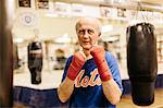 Senior man with his fists raised at boxing training