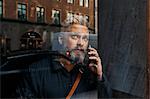 Man on smart phone through window in Sweden