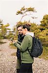 Hiking couple on smart phone in Sodermanland, Sweden