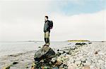 Man on rocky coastline at Sodermanland, Sweden