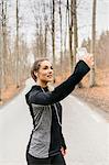 Young woman taking selfie on rural road in Sodermanland, Sweden