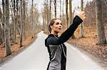 Young woman taking selfie on rural road in Sodermanland, Sweden