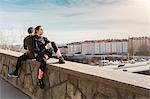Couple sitting on stone wall in Stockholm, Sweden