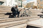 Man on staircase with bicycle in Sodermanland, Sweden