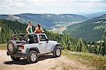 Road trip couple in parked four wheel convertible in Rocky mountains, Breckenridge, Colorado, USA
