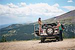 Road trip couple unpacking four wheel convertible in Rocky mountains, Breckenridge, Colorado, USA