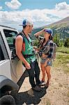Road trip couple leaning against off road vehicle in Rocky mountains, Breckenridge, Colorado, USA