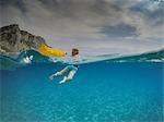 Over underwater view of boy looking back while swimming in blue sea, Varigotti, Liguria, Italy