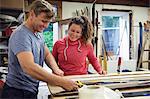 Man and woman in workshop, making ski equipment