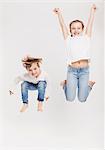 Portrait of brother and sister leaping in air