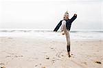 Young boy on beach, jumping, mid air