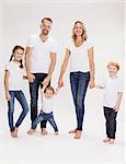 Studio portrait of mature couple holding hands with daughter  and sons, full length