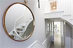 Reflection of foyer staircase in round mirror