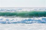 Seascape with breaking waves on sandy beach.