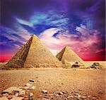 Pyramids in desert under ultra violet clouds