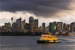 A ferry in Sydney Harbour at dusk with the Opera House and city skyline, Sydney, New South Wales, Australia, Pacific