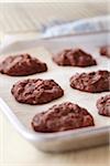 Freshly baked chocolate cookies on a cookie sheet with parchment paper