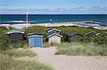 Beach huts among sand dunes with blue sea behind, Tisvilde, Kattegat Coast, Zealand, Denmark, Scandinavia, Europe