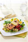 Salmon Nicoise salad with green beans, egg, potatoes, cherry tomatoes on a bed of letttuce