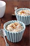 Rice pudding with sliced almonds in small blue bowls