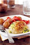 Chicken stuffed with herbs served with potatoes and red peppers