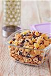 Healthy snack mix in a portable glass storage container with a water bottle