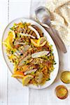 Platter of sliced chicken breast on couscous with orange and lemon slices