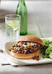 Sloppy Joe on a whole wheat bun with a side salad and glass of water