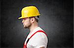 Side view of a sad construction worker with yellow hard hat