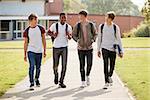 Group Of Male Teenage Students Walking Around College Campus
