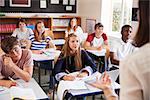 Students Listening To Female Teacher In Classroom