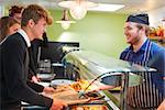 Teenage Students Being Served Meal In School Canteen