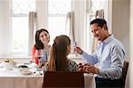 Jewish man holding kiddish cup blesses his family at Shabbat