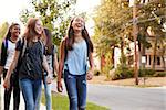 Four young teen girls walking to school, front view close up
