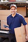 Portrait Of Courier With Digital Tablet Delivering Package