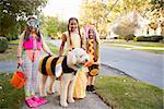 Children And Dog In Halloween Costumes For Trick Or Treating