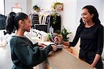 Woman making card payment at the counter in a clothing store